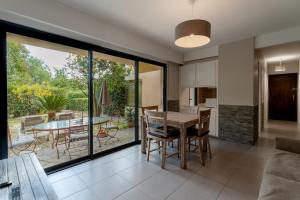 a kitchen and dining room with a table and chairs at Les Sarments in Le Lavandou +8 photos