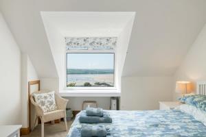a bedroom with a bed and a large window at Beautiful Home with Pool Overlooking Camel Estuary in Roche