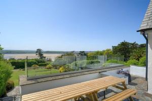 a wooden bench sitting on top of a balcony at Beautiful Home with Pool Overlooking Camel Estuary in Roche
