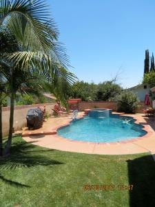 a swimming pool in a yard with a palm tree at Elegant private studio with private entrance and pool access in San Gabriel