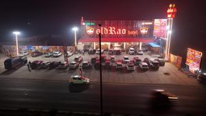 a parking lot with cars in front of a store at night at Old RAO Hotel Kotwan in Kosi