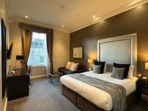 a hotel room with a large bed and a couch at Fraser Suites Edinburgh in Edinburgh