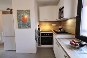 a kitchen with white cabinets and a white refrigerator at Casa 115 - Plage & piscine chauffée in Pianottoli-Caldarello