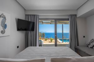 ein Schlafzimmer mit Bett und Meerblick in der Unterkunft Adrina Grand Hotel in Panormos Skopelos