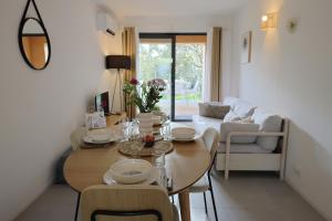 a living room with a table and a couch at Casa 115 - Plage & piscine chauffée in Pianottoli-Caldarello +42 photos