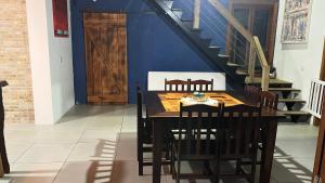 a dining room with a table and chairs and a staircase at Casa das Palmeiras in Imbituba