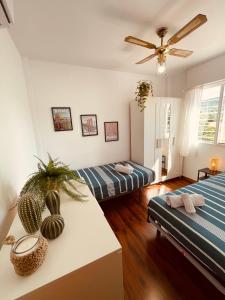 a room with two beds and a ceiling fan at Villa EMMA - Chalet familiar con jardín y parking en Málaga in Málaga