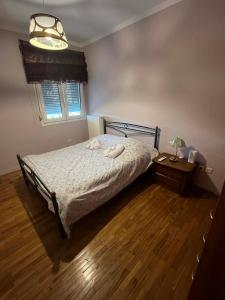 a bedroom with a bed and a table with a lamp at Renas' Apartments in Chios island in Chios
