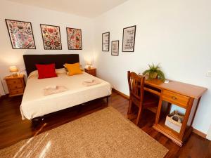 a bedroom with a bed and a table and a desk at Villa EMMA - Chalet familiar con jardín y parking en Málaga in Málaga