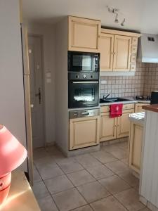 a kitchen with a stove and a microwave at Andrée in Lapalisse +1 photo