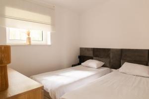 two beds in a small room with a window at Przystań Kormoran in Czarna Wieś