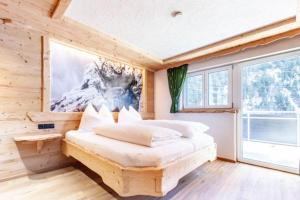 a bedroom with a bed and a large window at Casa de Wisa in Gaschurn