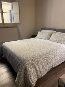 a bedroom with a bed with a blanket and pillows at LuccaStay 99 in Lucca