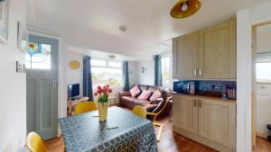 a kitchen and living room with a table and a couch at E08 Boness E8, Riviere Towans in Hayle