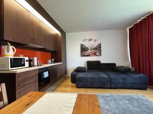 a living room with a bed and a microwave at Prime Apartmans in Balatonlelle