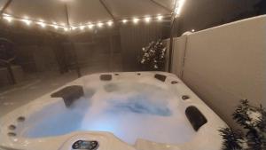 a white bath tub with lights in a bathroom at Cseresznyefa Vendégház in Dorog +25 photos