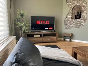 a living room with a tv and a couch at Gasthuys Rooy in Stramproy