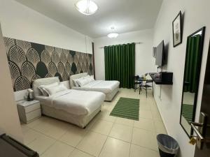 a hotel room with two beds and a television at AlWasl Guesthouse by PHM in Dubai