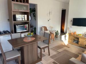a kitchen and living room with a table and chairs at Pousada Familiar da Dani - Casa em São Gabriel com piscina in São Gabriel