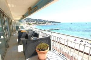 a balcony with chairs and a view of the beach at AMAZING SEA VIEW APARTMENT in Cannes +7 photos