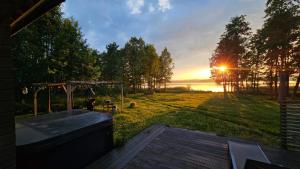 a view of a backyard with the sun setting over the water at Authentic Finnish Lakeside Cottage in Lusila
