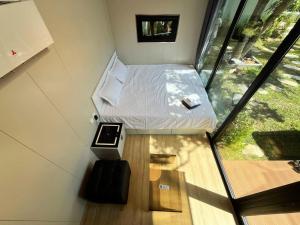 a small bed in a small room with a window at NeOtel Apartments in Ban Saiyuan (1)