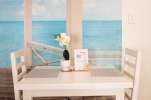a white table with a vase of flowers on it at Bella Luna Bed and Breakfast in Walvis Bay +32 photos