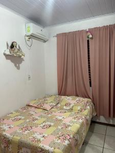 a bedroom with a bed and a pink curtain at Pousada Familiar da Dani - Casa em São Gabriel com piscina in São Gabriel +6 photos