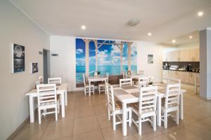 a dining room with white tables and white chairs at Bella Luna Bed and Breakfast in Walvis Bay