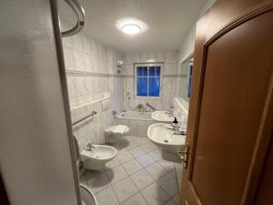 a bathroom with two sinks and two toilets at Hotel Zartenbach in Hinterzarten +34 photos