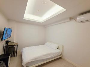a white room with a bed and a skylight at GaGa Hotel dongdaemun in Seoul