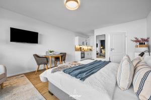 a white bedroom with a bed and a table at Ferienwohnung Seeblick 203 Büsum in Büsum