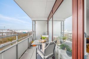 a balcony with a table and chairs and a view of the ocean at Ferienwohnung Seeblick 203 Büsum in Büsum