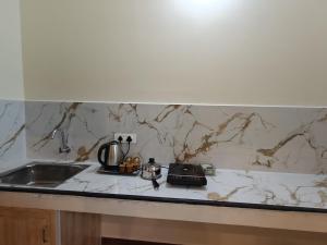 a kitchen counter with a sink and a counter top with a counter at TADY Homes in Tiruvannāmalai