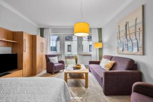 a living room with a purple couch and a table at Ferienwohnung Hummer Büsum in Büsum