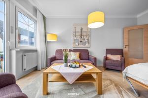 a living room with purple chairs and a coffee table at Ferienwohnung Hummer Büsum in Büsum +10 photos