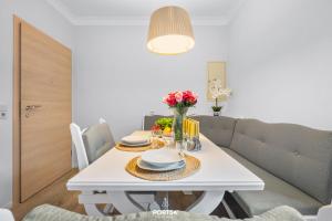 a white dining room table with plates and flowers on it at Ferienwohnung Hummer Büsum in Büsum