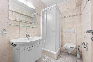 a bathroom with a shower and a sink and a toilet at Ferienwohnung Hummer Büsum in Büsum