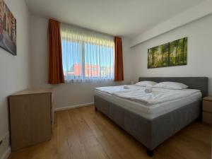 a bedroom with a bed and a large window at Prime Apartmans in Balatonlelle +12 photos