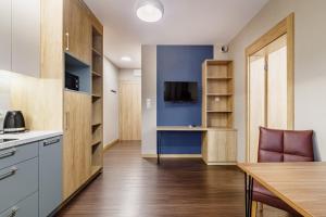 a kitchen and dining room with a table and a tv at Apartamenty Polna 60 in Żory