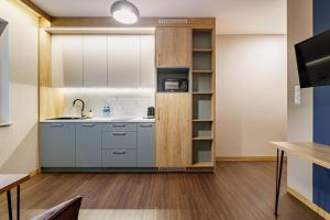 a kitchen with white cabinets and a sink at Apartamenty Polna 60 in Żory +46 photos