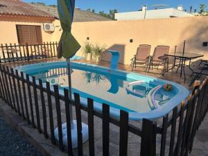 a pool with a table and chairs and an umbrella at Pousada Familiar da Dani - Casa em São Gabriel com piscina in São Gabriel