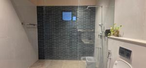 a shower with a glass door in a bathroom at Nirmala's Farmhouse - The Blu room in Kuttālam