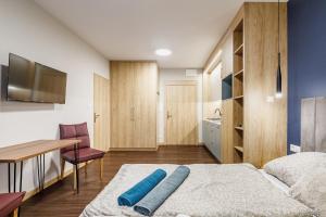 a bedroom with a bed and a table and a desk at Apartamenty Polna 60 in Żory