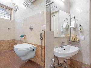 a bathroom with a toilet and a sink at Treebo Brixton Luxe in Bangalore