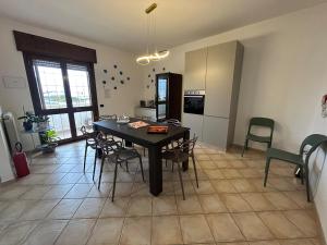 a kitchen and dining room with a table and chairs at Salento Casa Vacanza Il Focolare in Torchiarolo