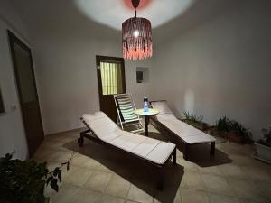 a room with two chairs and a table and a chandelier at Salento Casa Vacanza Il Focolare in Torchiarolo