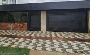 a building with two garage doors and a rug at Casa a 4 km do centro e Shopping Campo Grande in Campo Grande