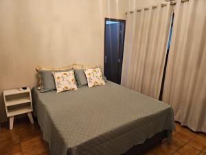 a bedroom with a bed in a room with a window at Casa a 4 km do centro e Shopping Campo Grande in Campo Grande