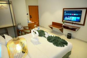 a living room with a white table with a television at MR Suites Dharwad in Dhārwād +23 photos